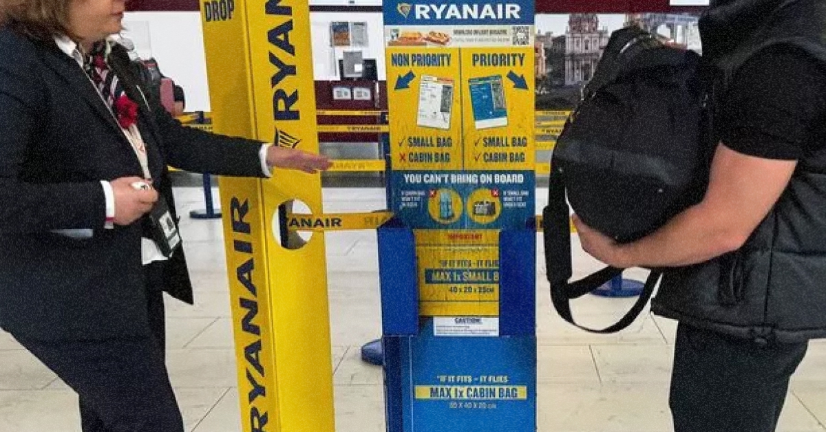 Працівник Ryanair перевіряє розмір валізи пасажира у вимірювальній рамці (сайзері)