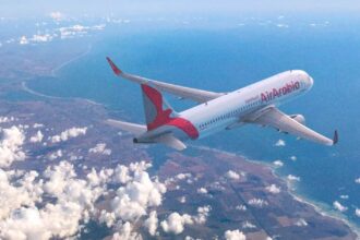 Літак авіакомпанії Air Arabia на тлі неба з хмарами