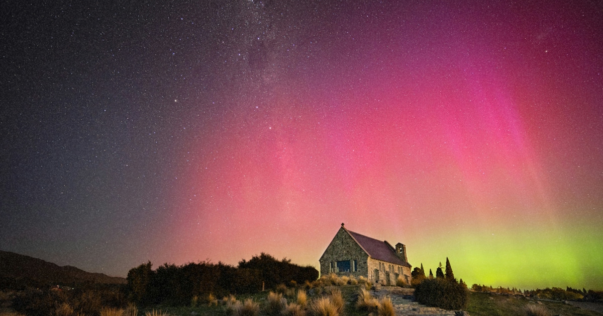 Яскраве зелене північне сяйво (aurora borealis) над засніженим пейзажем