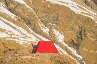 Червоний Бівак Фраттіні на сніжному хребті в Італійських Альпах, вид на гори