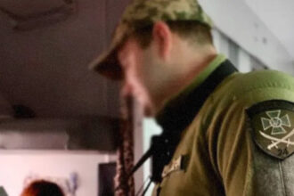 Прикордонник перевіряє паспорт у вагоні поїзда 'Укрзалізниця