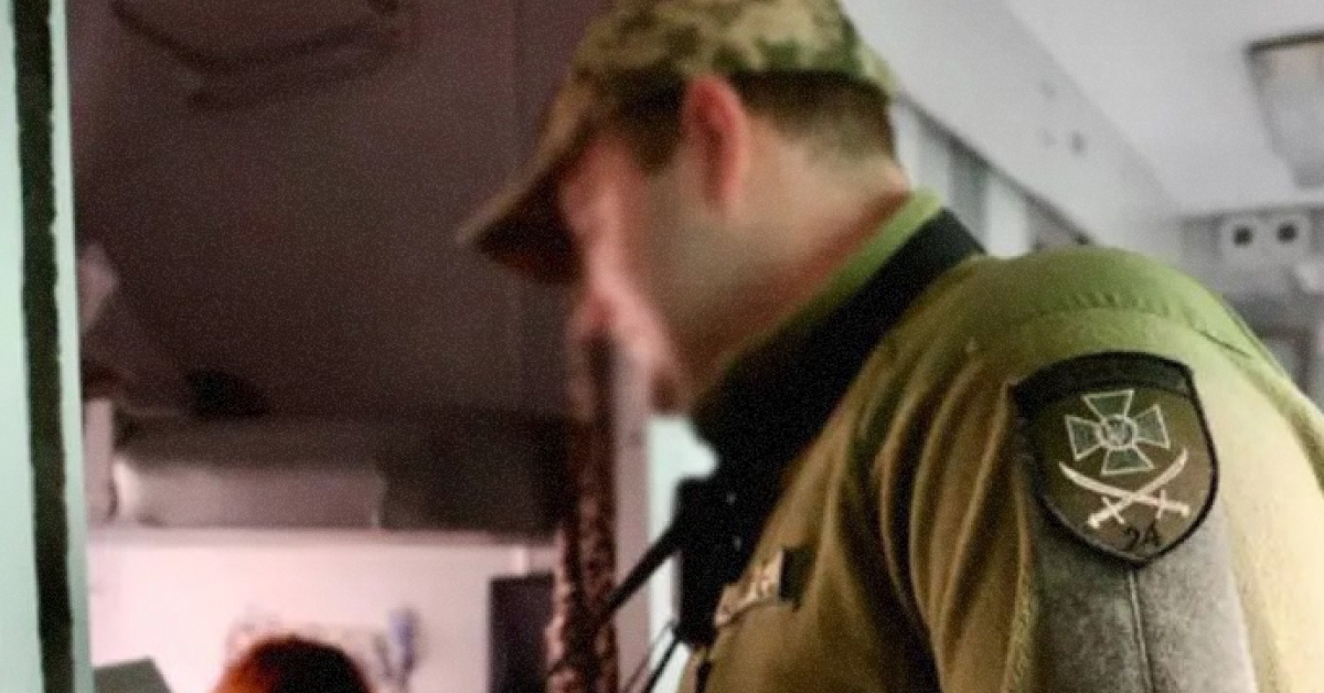 Прикордонник перевіряє паспорт у вагоні поїзда 'Укрзалізниця