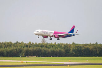 Літак Wizz Air Airbus A321neo у фірмовій лівреї на злітній смузі