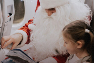 Різдвяний банер акції SkySanta з літаком та подарунками"