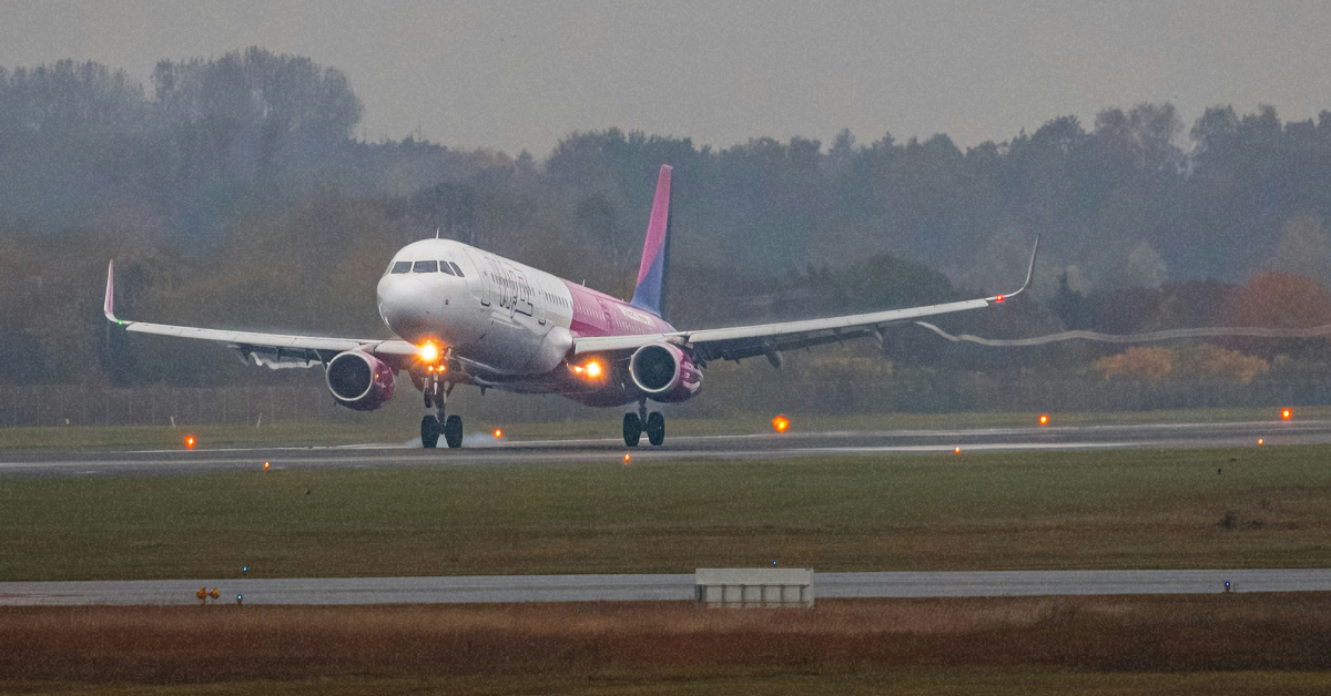 Літак Wizz Air Airbus A321 у фірмовій лівреї на тлі зимової злітньої смуги