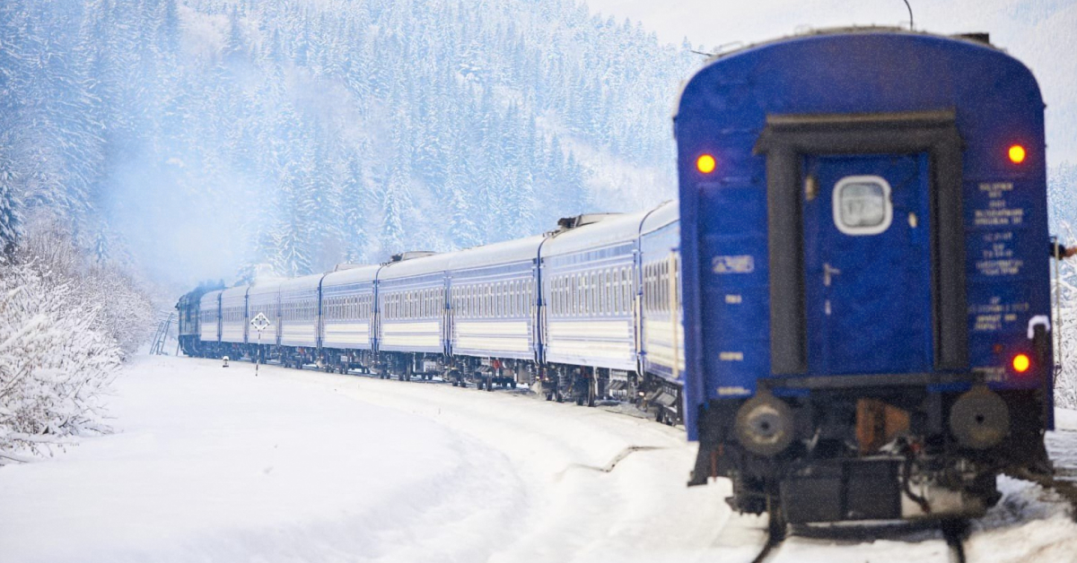 Пасажирський поїзд Укрзалізниці проїжджає крізь засніжені Карпати під час циклону