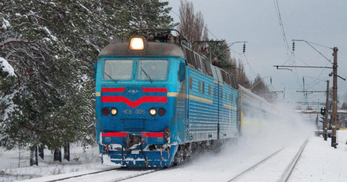 Пасажирський поїзд Укрзалізниці на тлі засніжених Карпатських гір