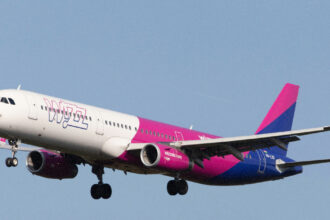 Літак Wizz Air у небі на фоні яскравого сонця