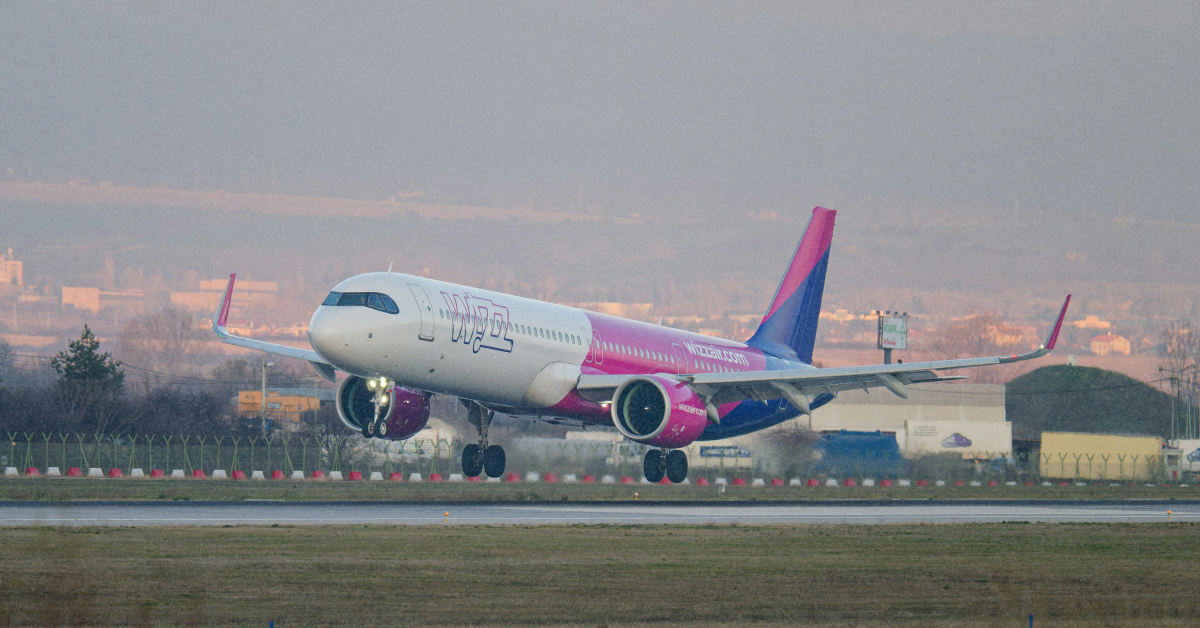 Літак Wizz Air на злітній смузі під час весняного заходу сонця