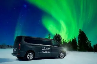 Яскраве зелене північне сяйво над засніженим лісом у Лапландії