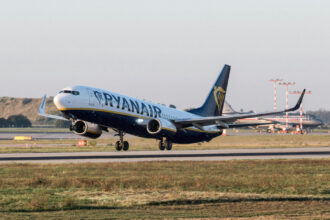 Літак Ryanair на фоні блакитного неба під час посадки