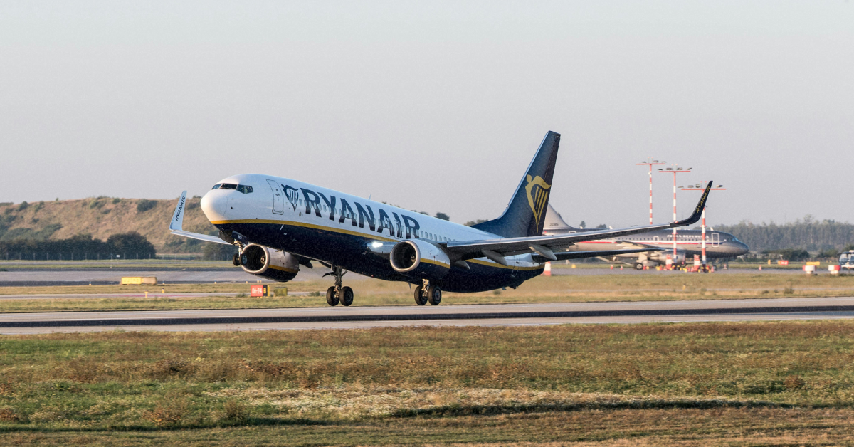 Літак Ryanair на фоні блакитного неба під час посадки
