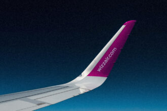 Рожевий літак Wizz Air готується до зльоту на тлі весняного неба