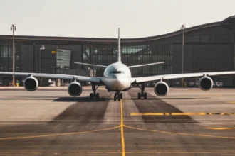 Пасажирський літак на заправці в аеропорту на фоні паливних цистерн