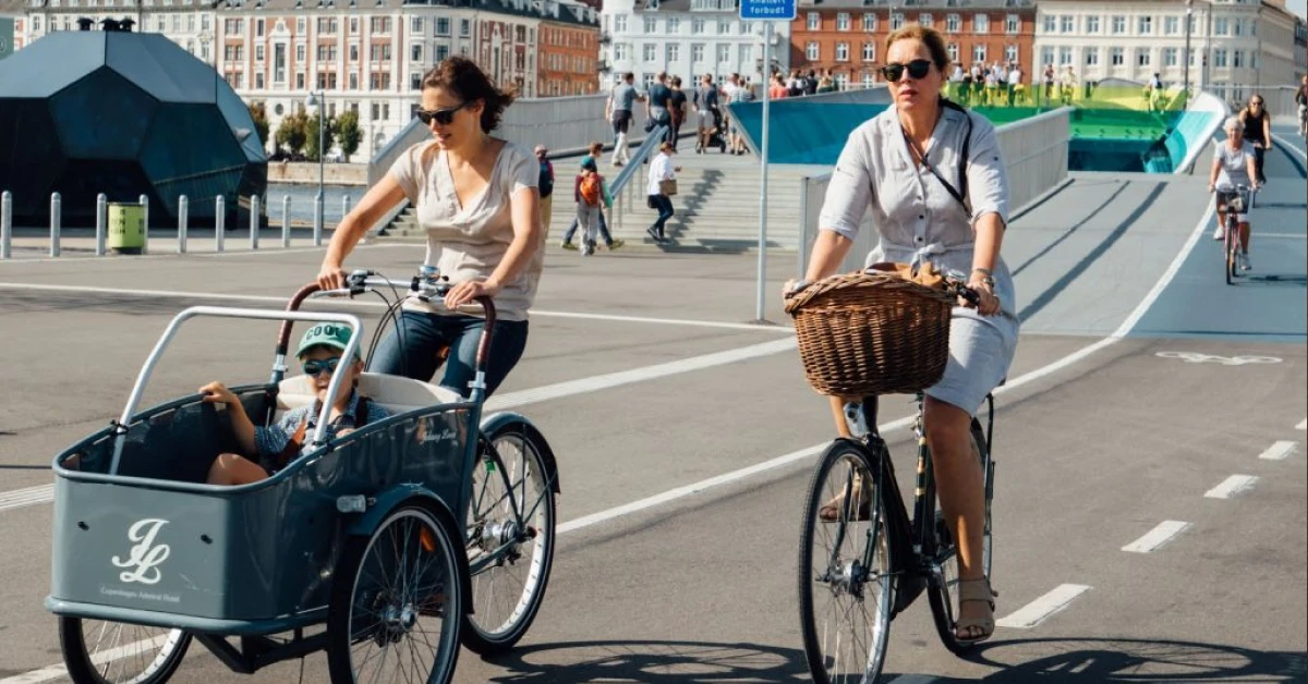 Батьки з дитячим візком гуляють інклюзивною площею європейського міста"