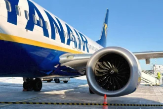 Літак Ryanair у синьо-жовтій лівреї на тлі хмар під час весняного рейсу