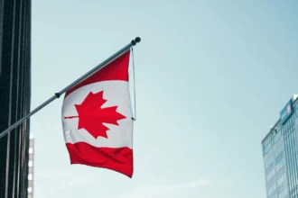 Прапор Канади на фоні будівлі парламенту в Оттаві
