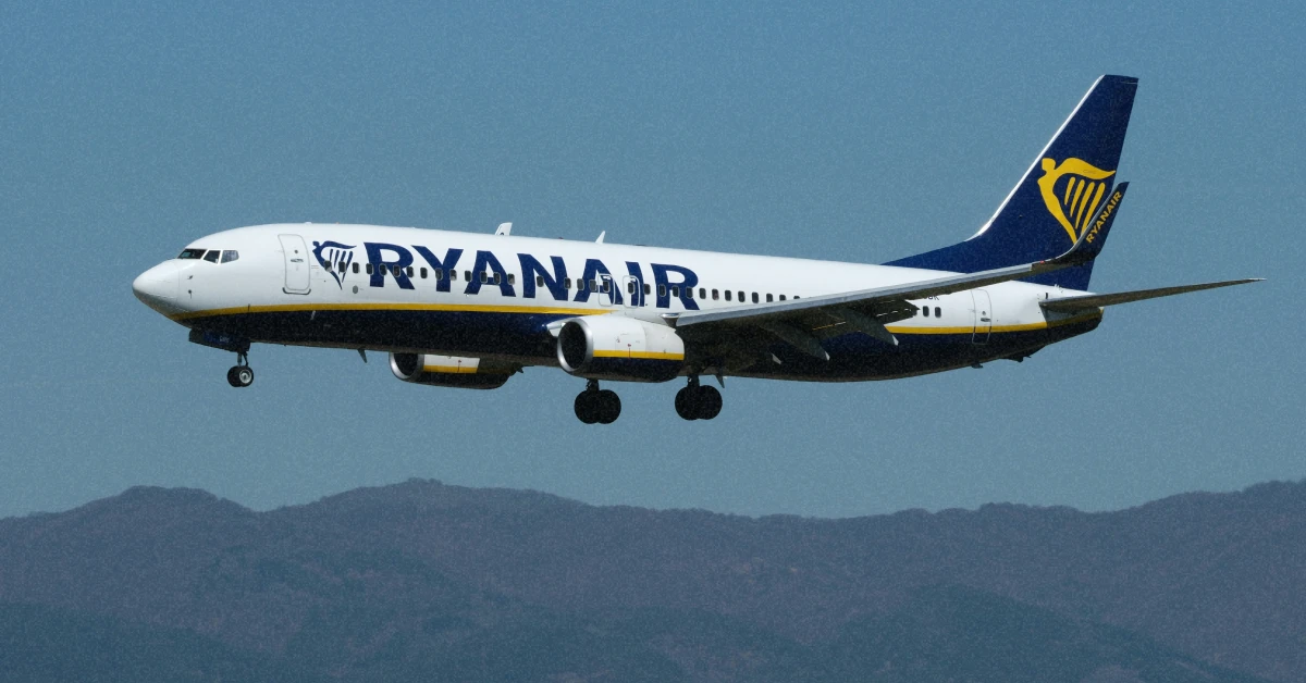 Літак Ryanair у небі на фоні яскравого весняного сонця