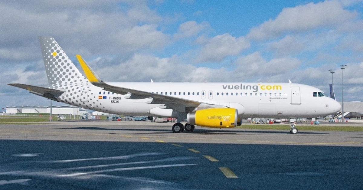 Літак Vueling на тлі сонячного неба Барселони