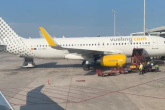 Літак лоукостера Vueling на фоні узбережжя Барселони