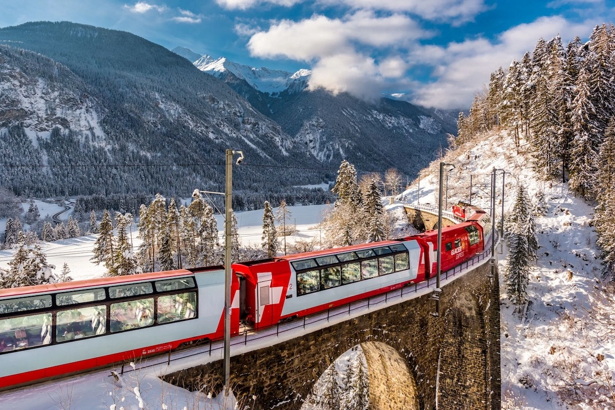 потяг Glacier Express (Швейцарія) на тлі засніжених гір