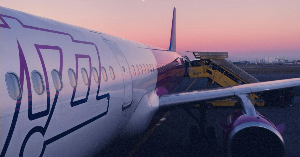 Літак Wizz Air на тлі яскравого вечірнього неба перед посадкою