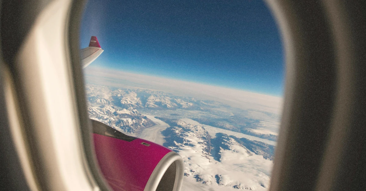 Яскраво-рожевий літак Wizz Air піднімається у небо в сонячний літній день