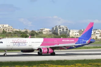 Святковий літак Wizz Air на злітній смузі в променях сонця
