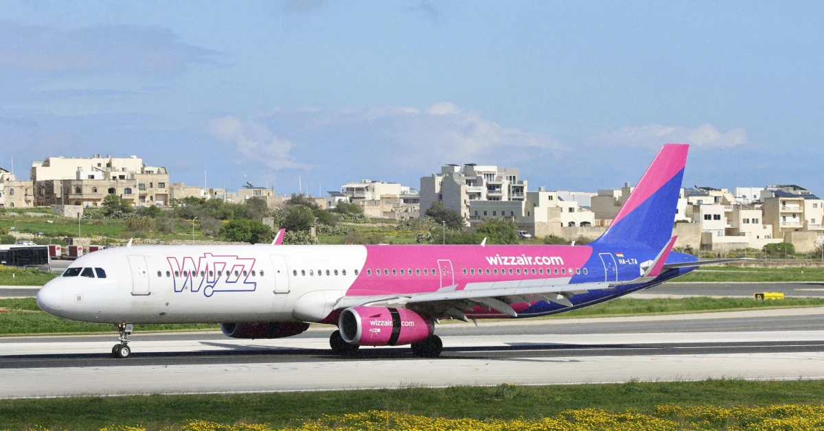 Святковий літак Wizz Air на злітній смузі в променях сонця