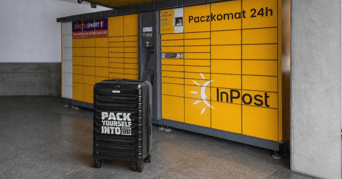 Мандрівник закладає велику валізу у комірку яскравого поштомату InPost у Польщі"