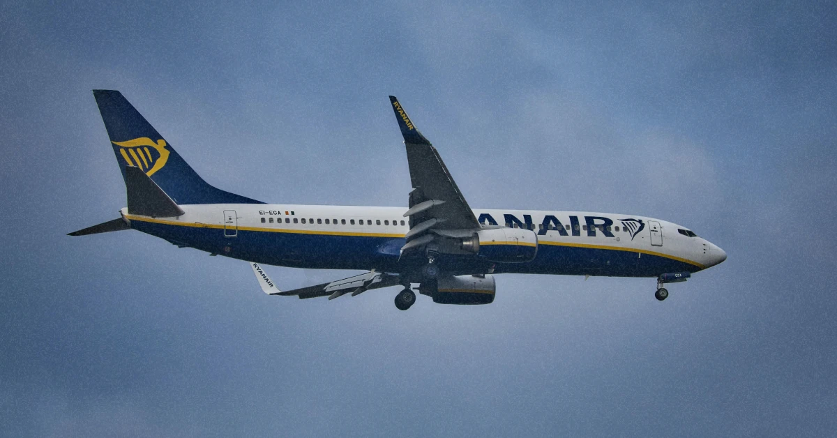 Літак Ryanair у небі на тлі яскравого літнього сонця