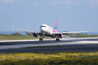 Літак Wizz Air на тлі яскравого сонця заходить на посадку в аеропорту Рима