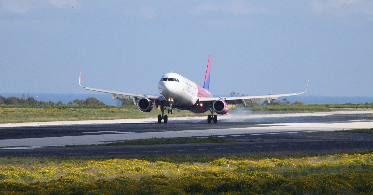 Літак Wizz Air на тлі яскравого сонця заходить на посадку в аеропорту Рима