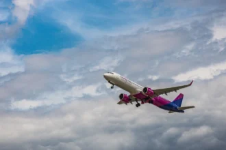 Фірмовий рожево-білий літак Wizz Air на злітній смузі в сонячний день