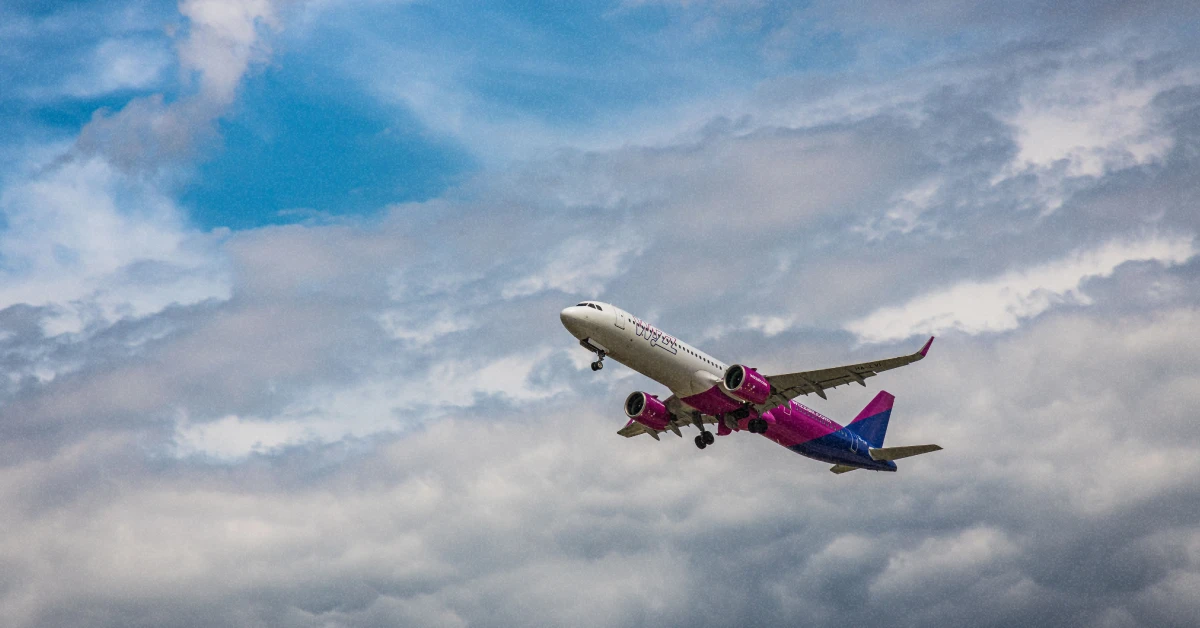 Фірмовий рожево-білий літак Wizz Air на злітній смузі в сонячний день
