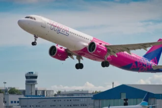 Фірмовий рожево-білий літак Wizz Air на злітній смузі у сонячний день