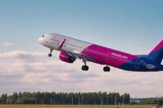 "Фірмовий рожево-білий літак Wizz Air на злітній смузі у сонячний день