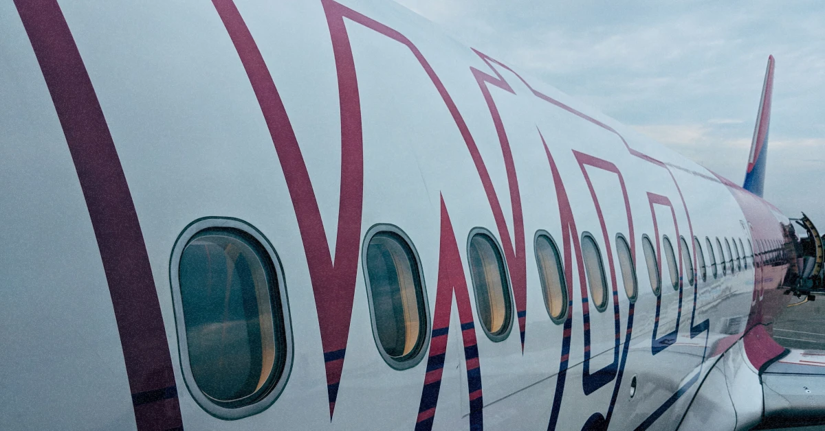 Фірмовий рожево-білий літак Wizz Air на злітній смузі