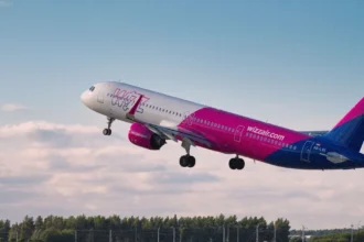 Фірмовий рожево-білий літак Wizz Air на злітній смузі у сонячний день