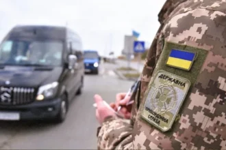 Прикордонник перевіряє документи водія на в'їзді до пункту пропуску